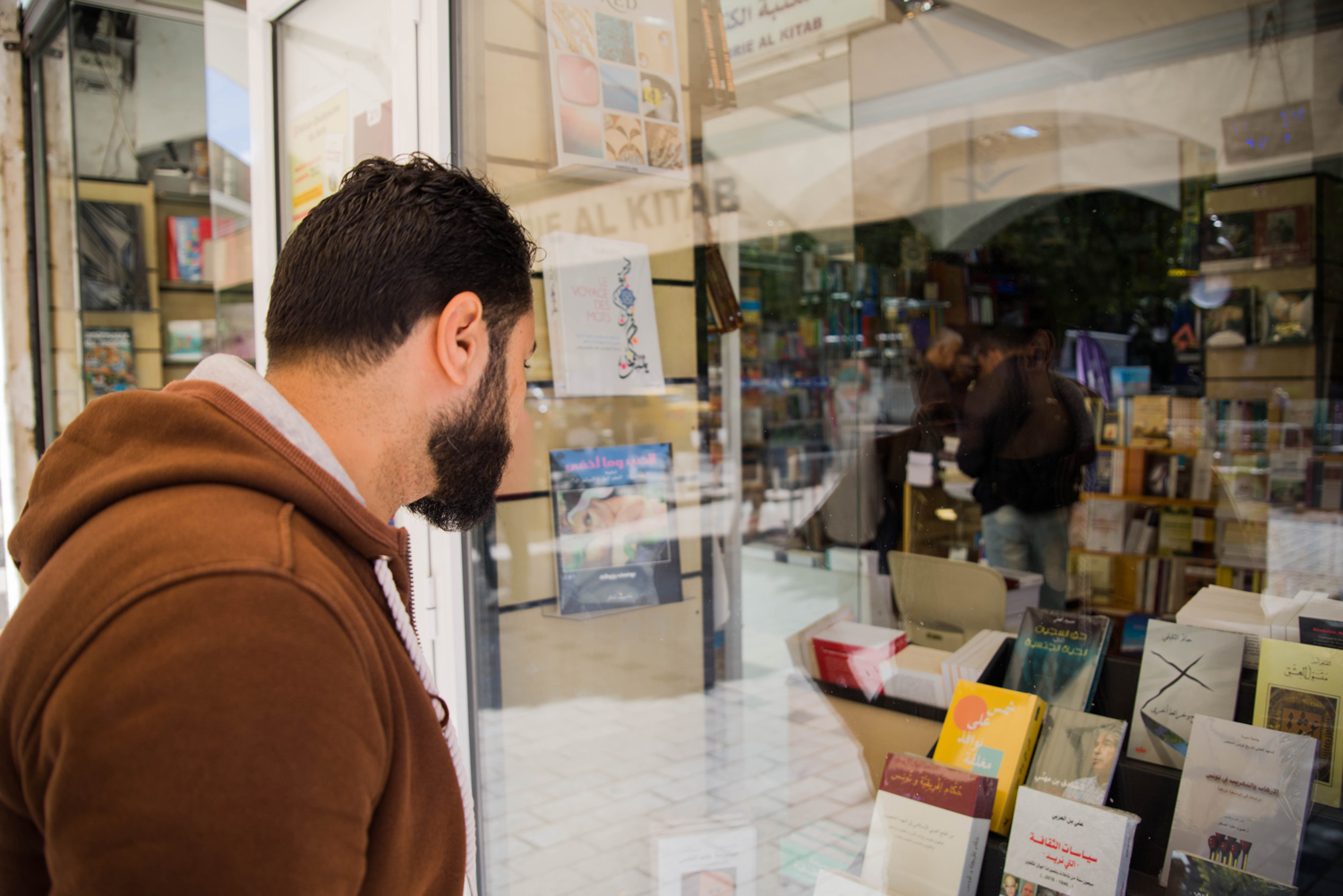Hosam Athani looks at a copy of Sun on Closed Windows in a bookstore in Tunis.
