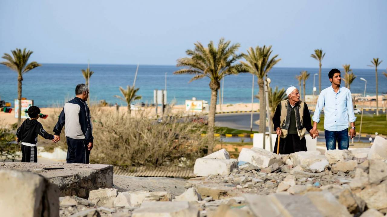 Families look at the bombed Al Andalusi shrine in 2013, a very significant icon of the city of Tajoura, in the east of Tripoli.