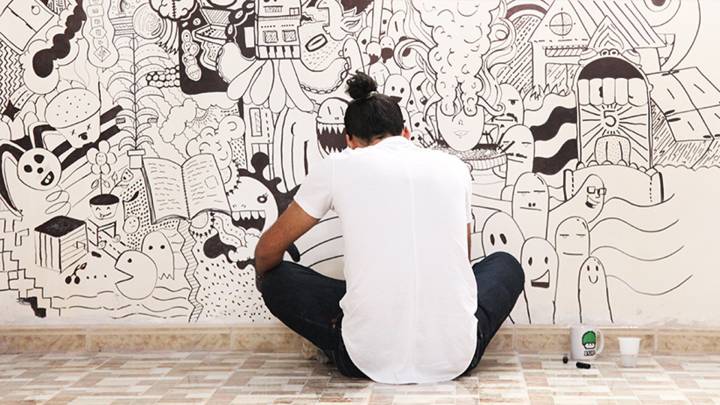 Designer Khaled Bader drawing a mural in the new Tanarout centre.